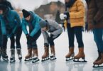 Les gens se préparent à patiner sur la patinoire, en enfilant des vêtements chauds, des chaussettes épaisses et des bottes robustes. Certains serrent leurs patins, d'autres ajustent leurs casques.