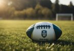 Un ballon de rugby repose sur un terrain dherbe entoure de maillots et de shorts de rugby. Le soleil projette une lueur chaleureuse sur la scene